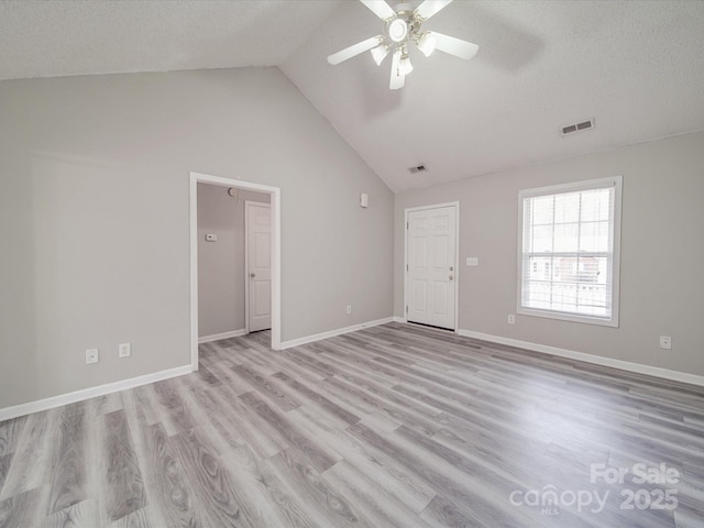 interior space featuring visible vents, a ceiling fan, a textured ceiling, light wood-style floors, and baseboards