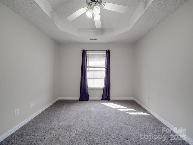 unfurnished room featuring visible vents, a tray ceiling, a textured ceiling, carpet, and ceiling fan