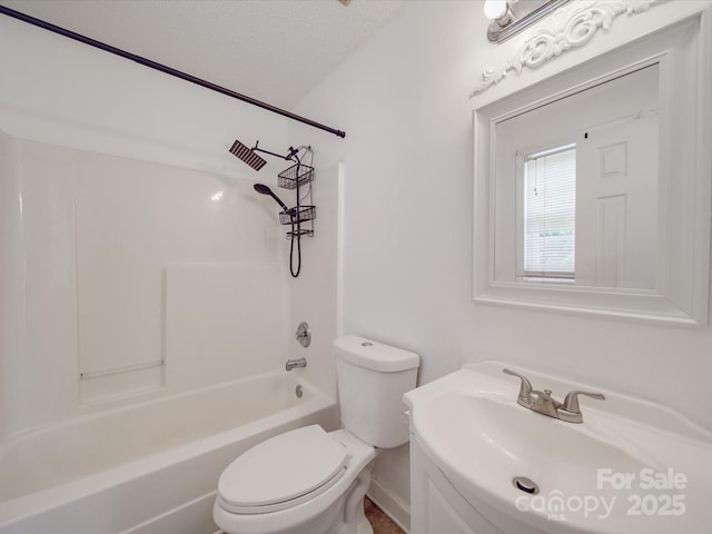 bathroom with shower / washtub combination, toilet, a textured ceiling, and a sink