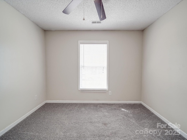 unfurnished room with visible vents, baseboards, carpet, ceiling fan, and a textured ceiling