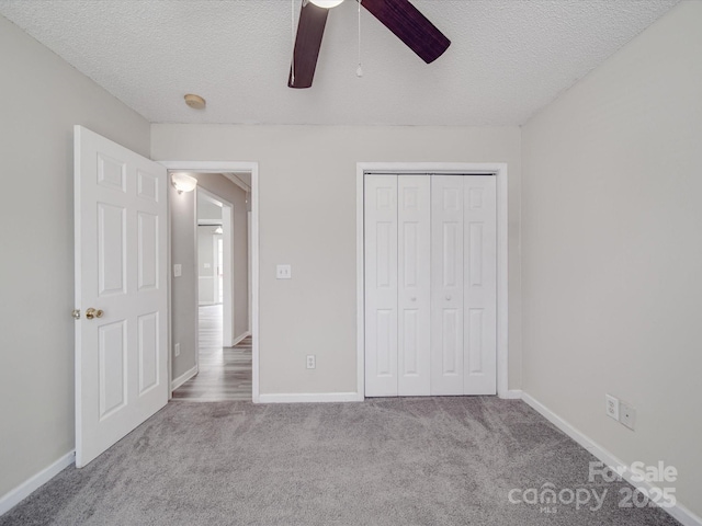 unfurnished bedroom featuring a closet, baseboards, a textured ceiling, and carpet