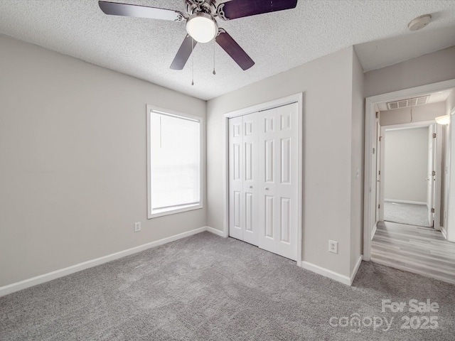 unfurnished bedroom with carpet, visible vents, a closet, and baseboards