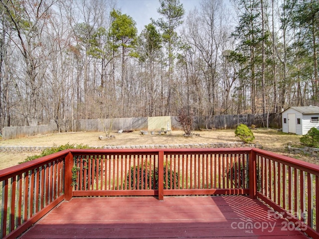 wooden terrace with a fenced backyard, a shed, and an outdoor structure