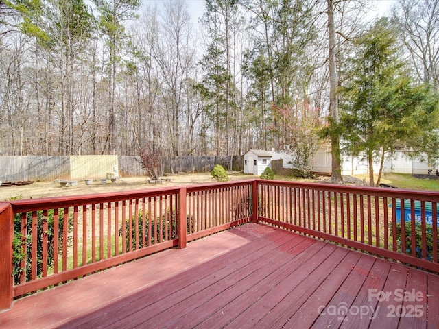 deck featuring a fenced backyard, a shed, and an outdoor structure