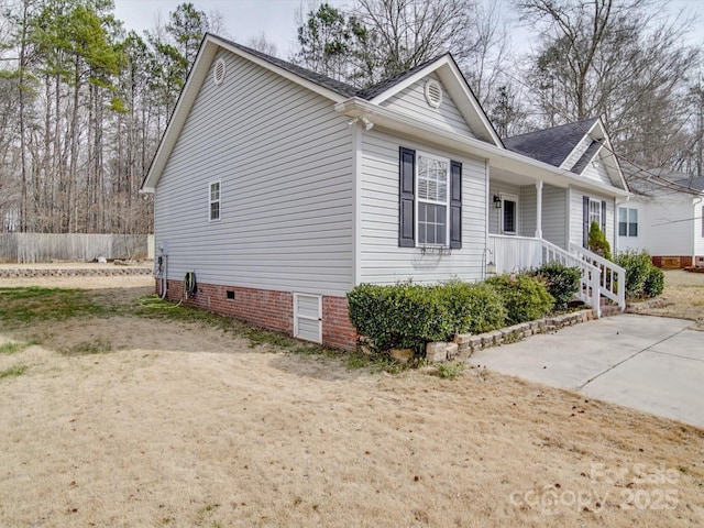 view of side of home with fence, driveway, and roof with shingles