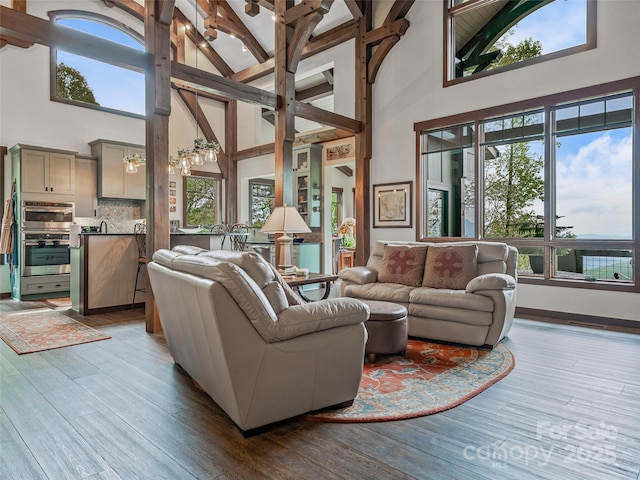 living room featuring beam ceiling, high vaulted ceiling, and wood finished floors