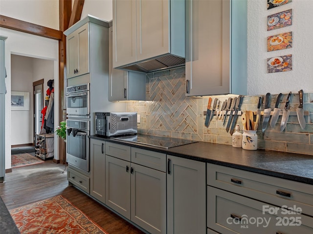 kitchen featuring dark countertops, stainless steel double oven, gray cabinets, and black electric cooktop