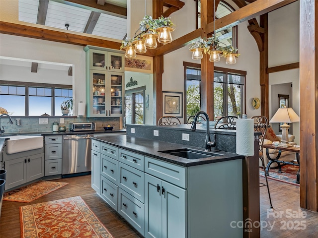 kitchen featuring a sink, a kitchen breakfast bar, stainless steel dishwasher, and an island with sink