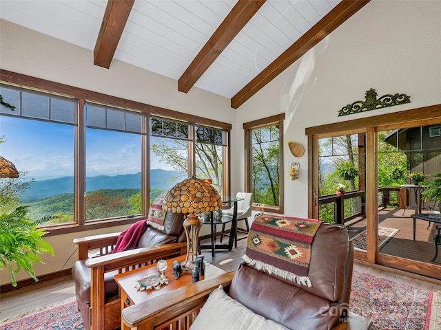 sunroom with lofted ceiling with beams and a mountain view