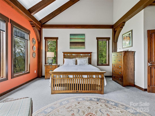 carpeted bedroom with multiple windows, vaulted ceiling with beams, and baseboards