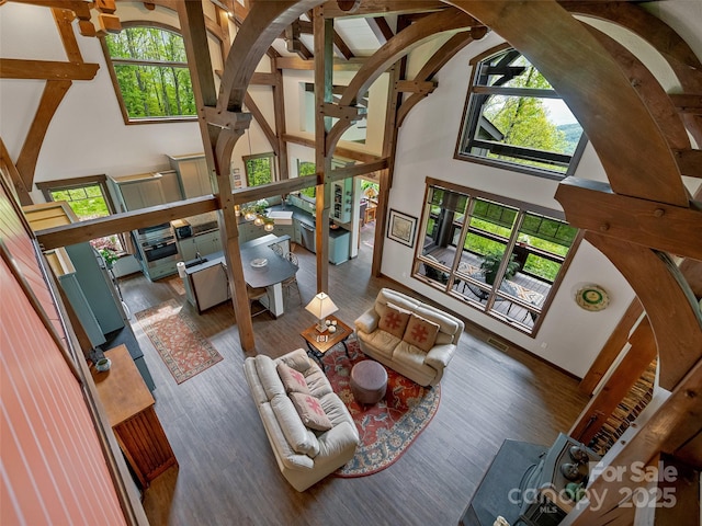 living room featuring beam ceiling, wood finished floors, and high vaulted ceiling