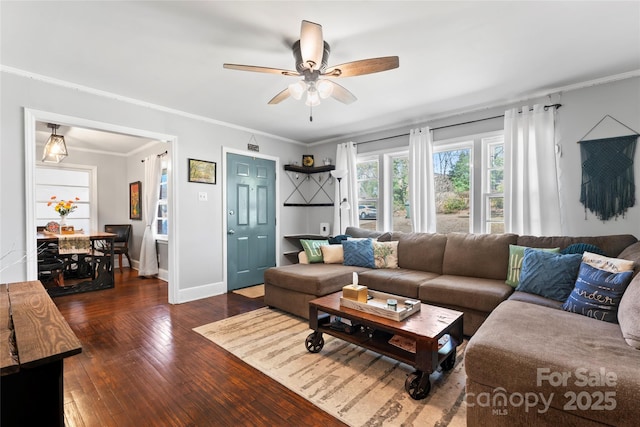 living area with crown molding, baseboards, wood-type flooring, and ceiling fan