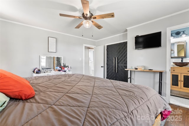 bedroom with a sink, wood finished floors, ornamental molding, and a ceiling fan