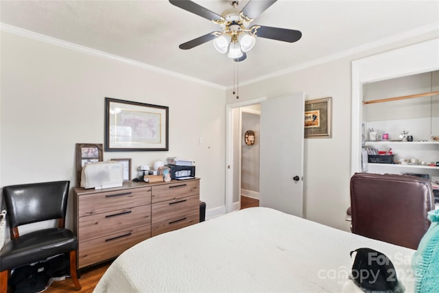 bedroom with baseboards, wood finished floors, ceiling fan, and ornamental molding