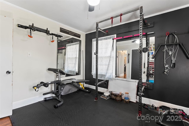 exercise area with a ceiling fan, baseboards, and ornamental molding