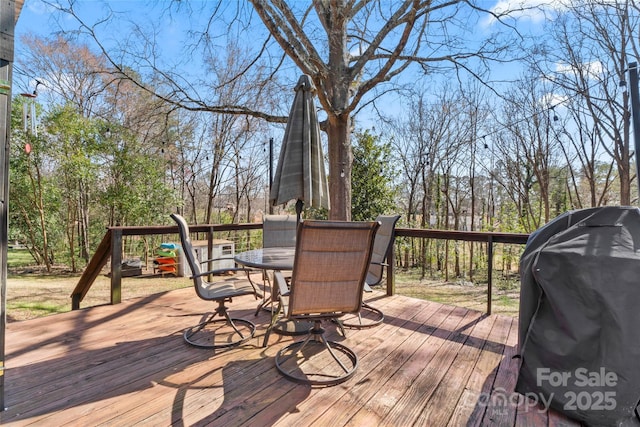 deck with outdoor dining space and a grill