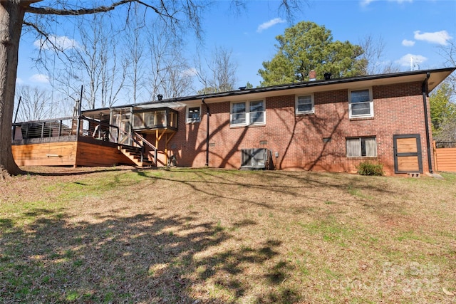 back of house featuring a yard, brick siding, and a wooden deck