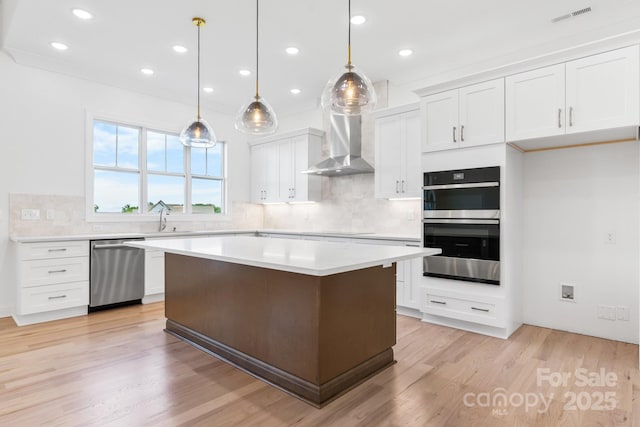 4227 Holly Cir NE, Conover, NC 28613 - kitchen featuring decorative backsplash, light countertops, white cabinets, stainless steel appliances, and wall chimney exhaust hood