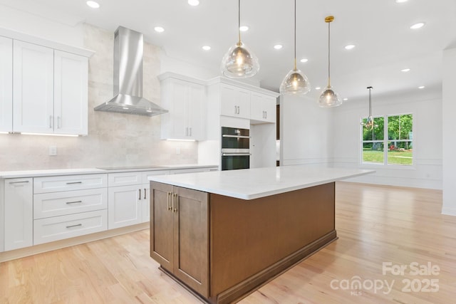 4227 Holly Cir NE, Conover, NC 28613 - kitchen with double oven, white cabinetry, light wood-style floors, and wall chimney range hood
