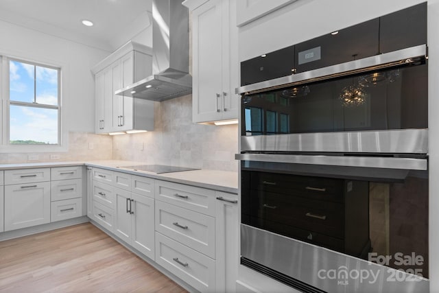 4227 Holly Cir NE, Conover, NC 28613 - kitchen featuring double oven, black electric stovetop, wall chimney range hood, light countertops, and white cabinetry