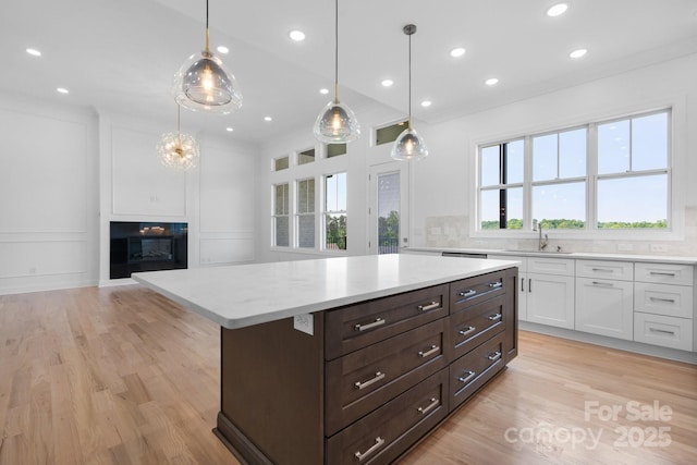 4227 Holly Cir NE, Conover, NC 28613 - kitchen featuring decorative backsplash, light wood-type flooring, a sink, white cabinets, and a decorative wall