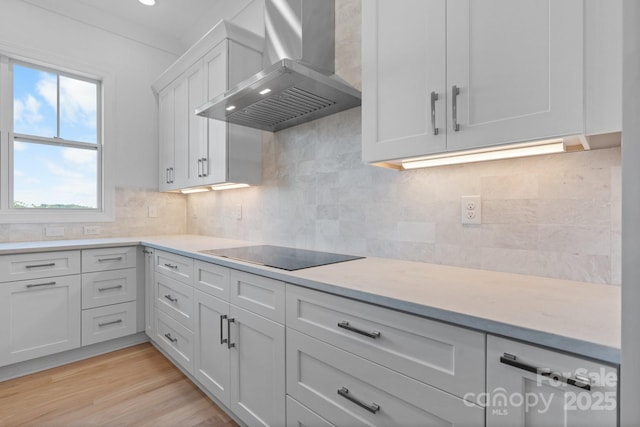 4227 Holly Cir NE, Conover, NC 28613 - kitchen with black electric stovetop, wall chimney range hood, light countertops, white cabinetry, and backsplash
