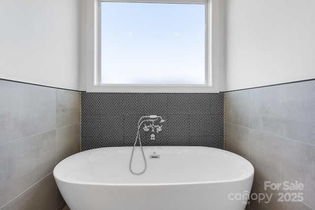 4227 Holly Cir NE, Conover, NC 28613 - bathroom featuring a freestanding tub, tile walls, and plenty of natural light