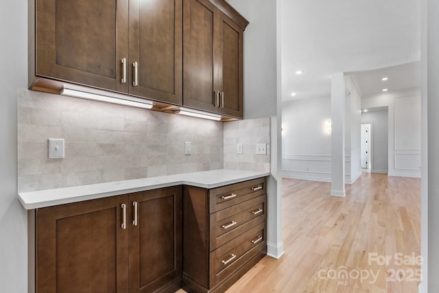 4227 Holly Cir NE, Conover, NC 28613 - kitchen featuring light countertops, light wood-style flooring, dark brown cabinets, and tasteful backsplash