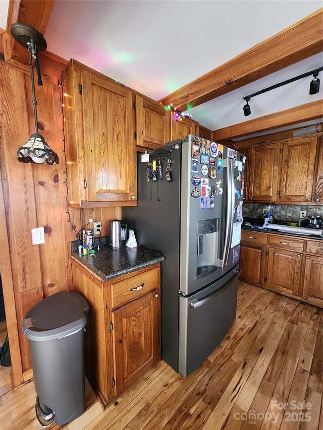 kitchen featuring tasteful backsplash, brown cabinets, light wood-type flooring, and stainless steel fridge with ice dispenser