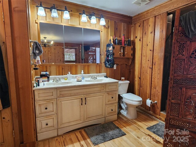 bathroom with toilet, wood-type flooring, and a sink