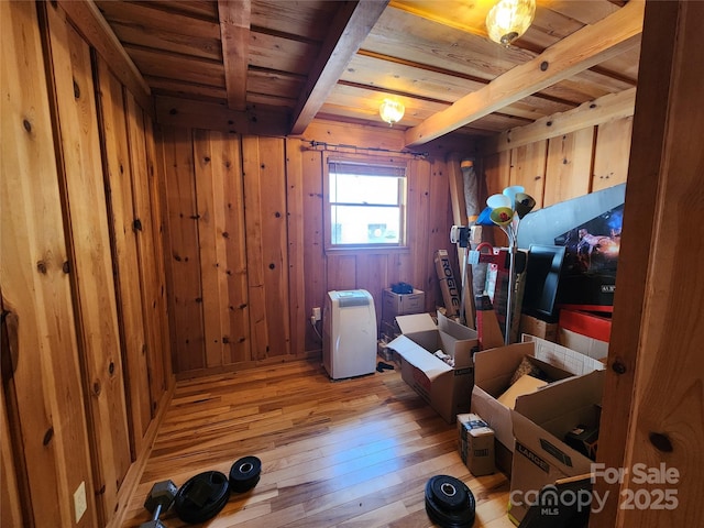 additional living space with beamed ceiling, wood walls, wooden ceiling, and hardwood / wood-style flooring