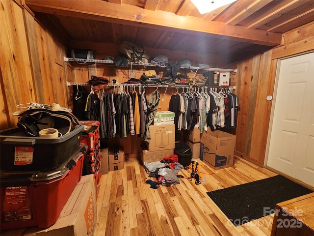 spacious closet with beamed ceiling and wood finished floors