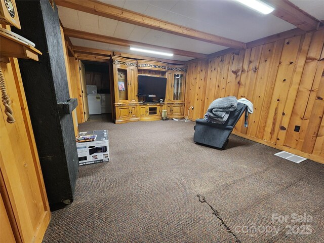 interior space with beamed ceiling, wooden walls, visible vents, and carpet flooring