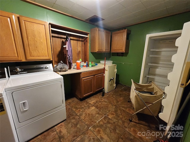 clothes washing area with cabinet space and washing machine and clothes dryer