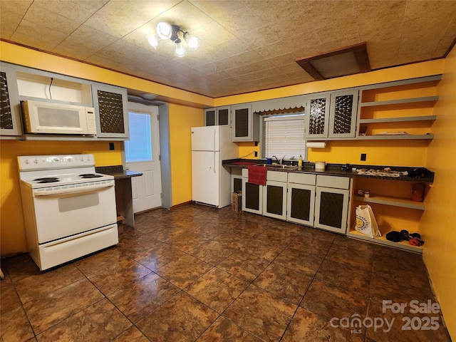 kitchen featuring open shelves, glass insert cabinets, white appliances, and dark countertops