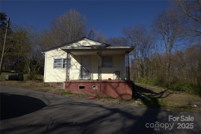 view of side of home featuring covered porch