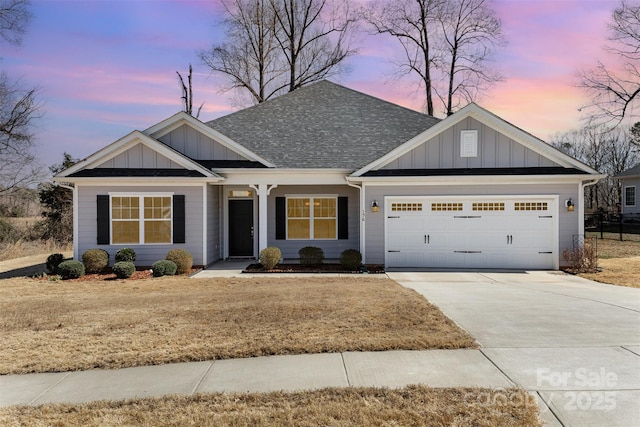 view of front facade featuring board and batten siding, concrete driveway, an attached garage, and a shingled roof