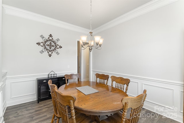 dining room featuring a wainscoted wall, dark wood-type flooring, an inviting chandelier, and ornamental molding