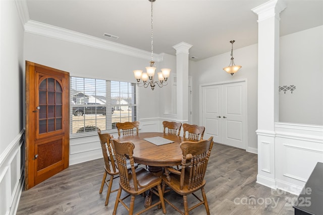 dining space with a decorative wall, decorative columns, wood finished floors, and visible vents