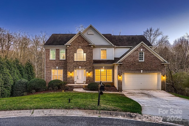 traditional-style home with a front lawn, an attached garage, brick siding, and driveway