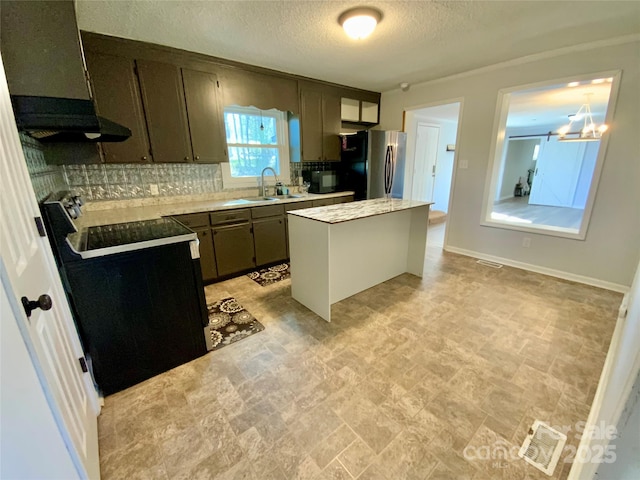 kitchen with a sink, black appliances, light countertops, backsplash, and a center island