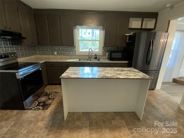 kitchen with under cabinet range hood, a sink, a kitchen island, stainless steel appliances, and light countertops