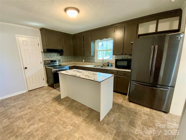 kitchen featuring a sink, light countertops, under cabinet range hood, appliances with stainless steel finishes, and tasteful backsplash