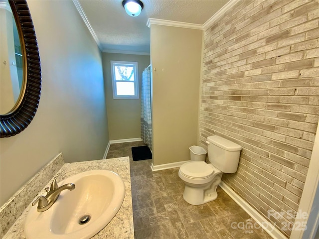 bathroom featuring baseboards, brick wall, a textured ceiling, crown molding, and toilet