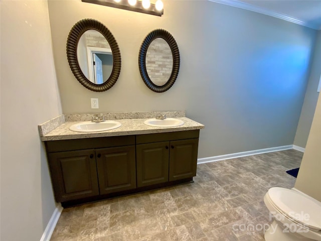 bathroom with crown molding, baseboards, and a sink