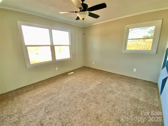 unfurnished bedroom with carpet floors, a ceiling fan, and crown molding