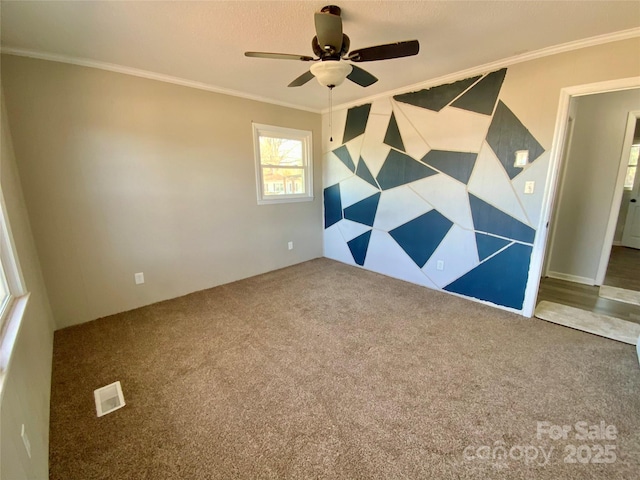 unfurnished room featuring visible vents, a ceiling fan, carpet, and ornamental molding