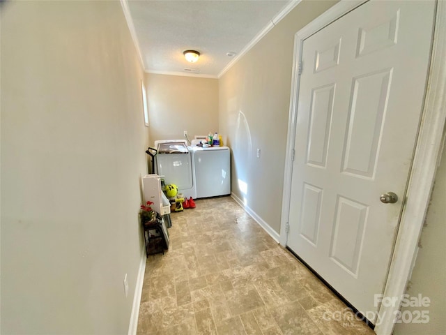 laundry area featuring baseboards, laundry area, crown molding, and washing machine and clothes dryer