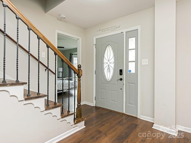 entryway featuring dark wood-style floors, stairs, and baseboards