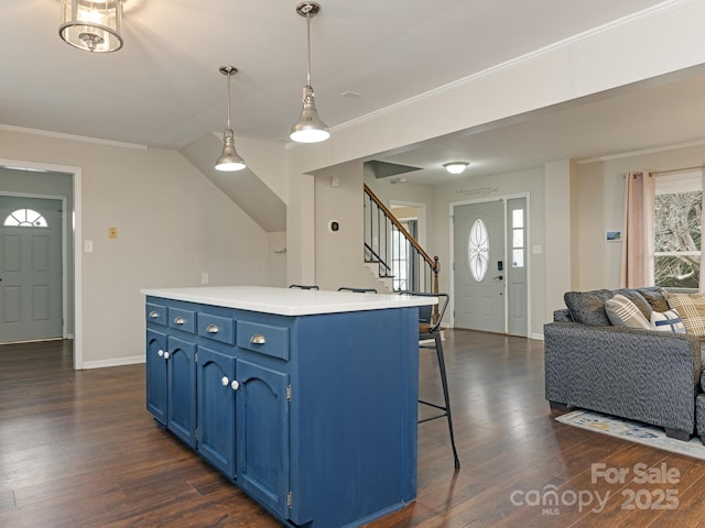 kitchen featuring crown molding, blue cabinetry, a breakfast bar area, and open floor plan